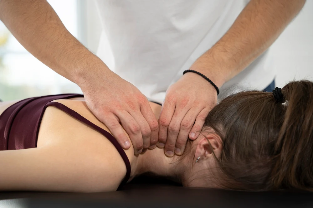 Chiropractor treating woman for neck pain during recovery