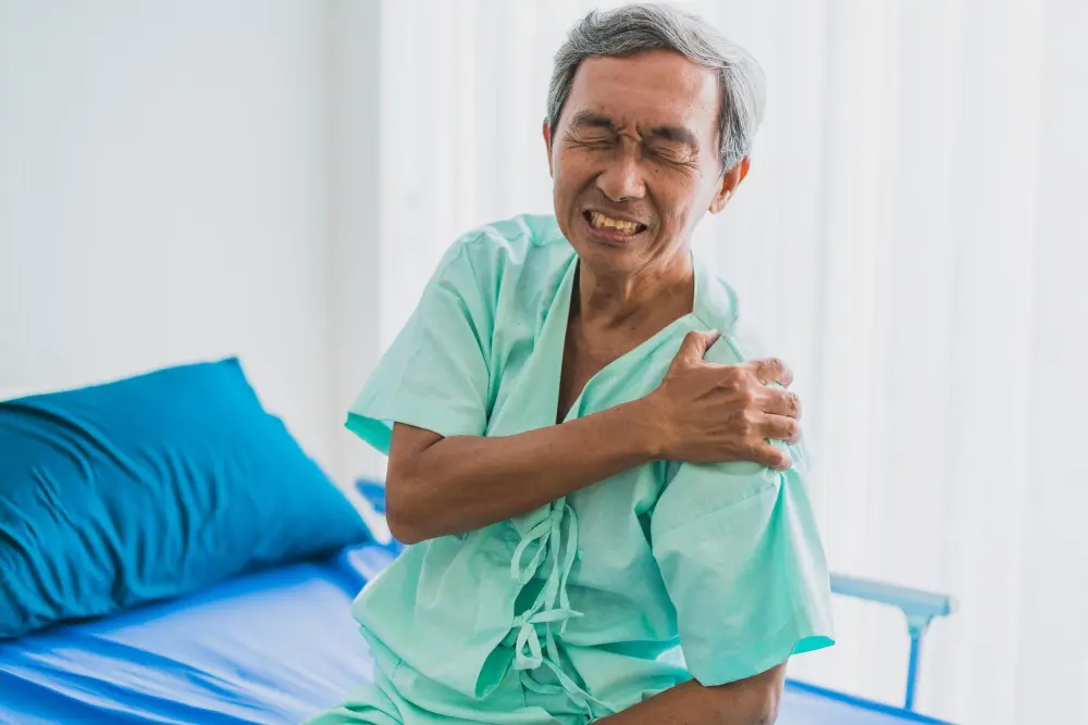 Grandfather in patient uniform suffering from arm and neck pain