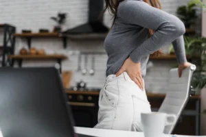 Office worker experiencing hip pain from prolonged sitting and poor posture