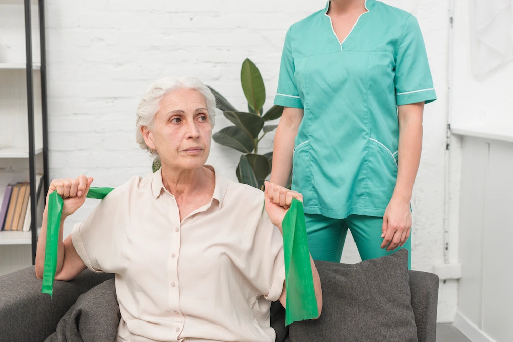 Therapist assisting elderly woman with physical therapy treatment