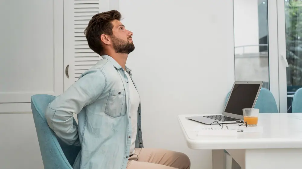 Side view adult male working from home with back pain