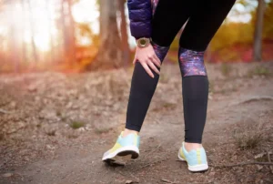 Person holding painful joints outdoors during cloudy or changing weather