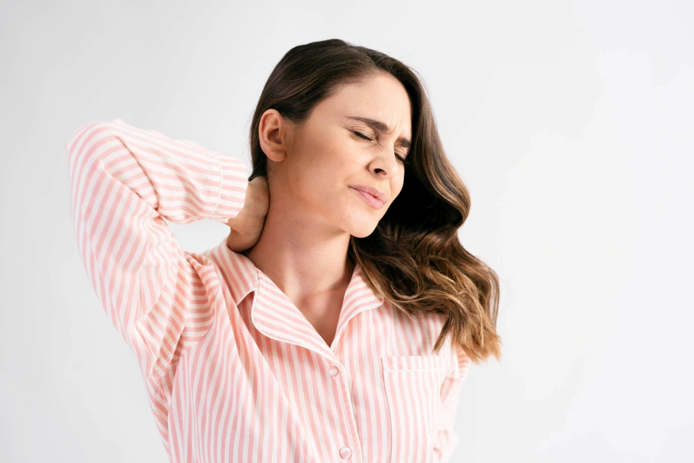 Young woman experiencing delayed whiplash neck pain