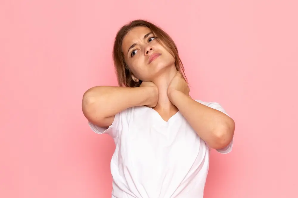 female in white shirt having a neckache