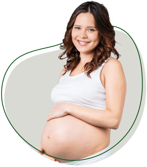 Why should I see a Chiropractor for pregnancy chiropractic section image. Pregnant person holding their protruding belly while smiling at the camera.