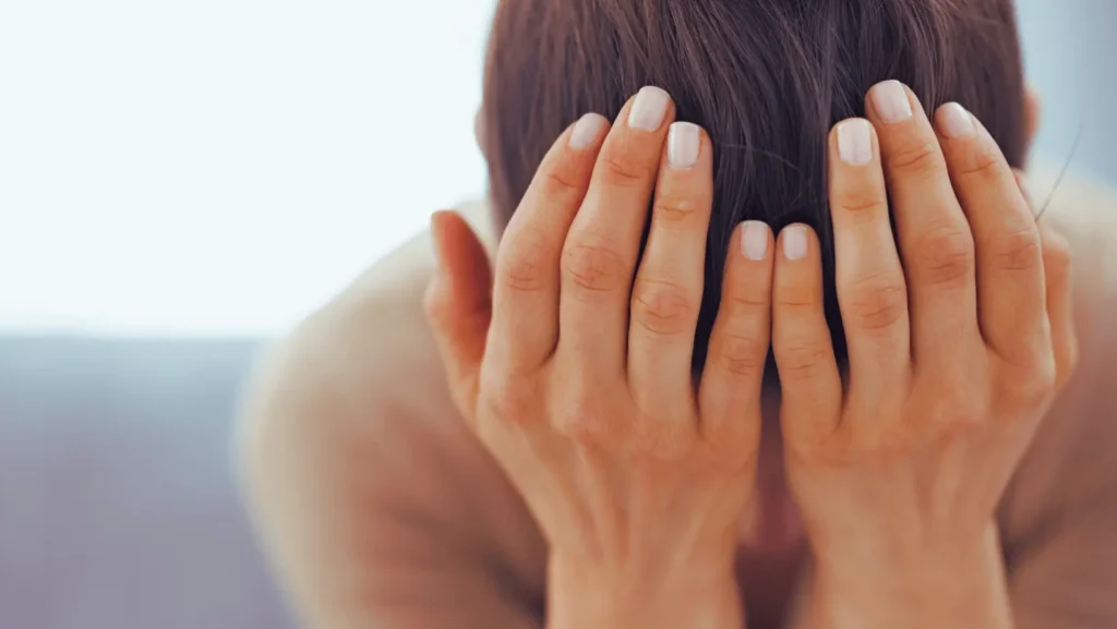 Woman with head in hands stressed
