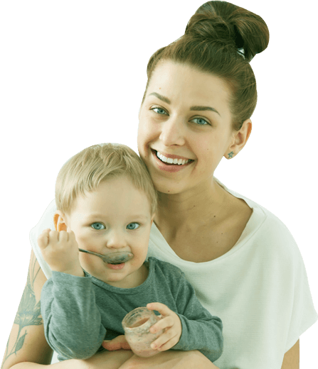 Gateway to Wellness Conditions page banner overlay image. A woman holds her toddler while they both face the camera. She is smiling, and the toddler is holding a spoon up to their mouth.