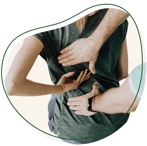 Patient facing away from the camera with their hand on behind their back in the middle. The practitioner has their hands placed just above and below the patient's, applying pressure.