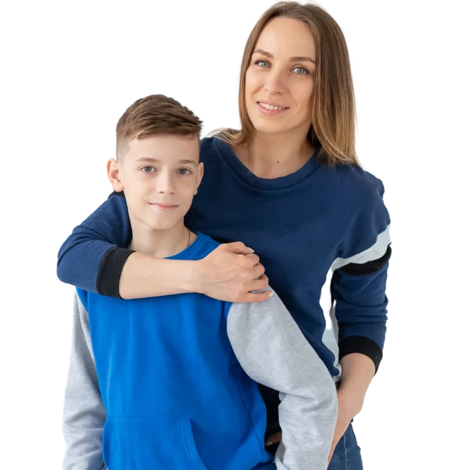 Mother standing behind son, hugging with one arm with her hand rest on his shoulder. They are both smiling at the camera.