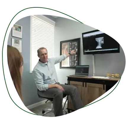 Chiropractor Dr Jon Guymon consulting a patient using spinal X-rays